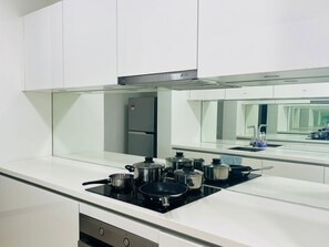 Familie appartement, uitzicht op stad | Privékitchenette | Een koelkast/vriezer, een waterkoker, kookgerei, borden en bestek