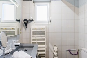 A modern bathroom with a large mirror, a towel rack, a heater, and a window. - AML - Atelier Musique & Lutherie - Appt 20 min de Metz (Gandrange)