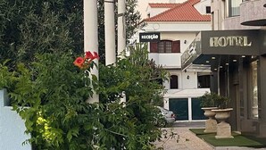 Een hotel met een receptie, een auto voor de ingang en een pad dat naar de entree leidt.