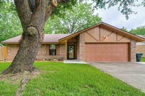 A residential house with a brick exterior, a garage, and a large tree in the front yard. - 4 Mi to Texas A&M! Cozy Home Away From Home (College Station)