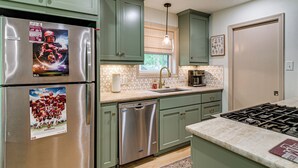 A kitchen with stainless steel appliances, green cabinets, a dishwasher, and a window with blinds. - 4 Mi to Texas A&M! Cozy Home Away From Home (College Station)