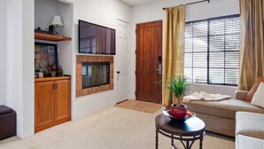 A living room with a fireplace, a television, a sofa, and a coffee table.