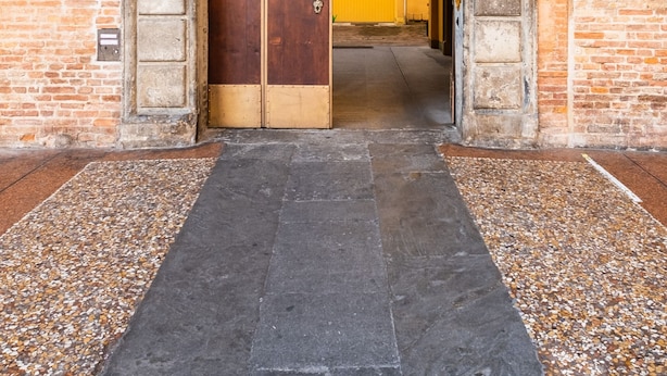 An arched entrance to a building with a wooden door and a brick wall. - Santo Stefano Design Apartment by Wonderful Italy (Bologna)