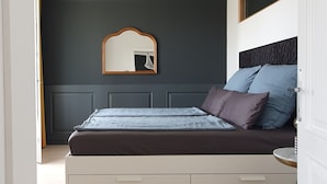 A bedroom with a bed, a mirror, and a dresser. - MoMa Escape Kecskemét (Kecskemét)