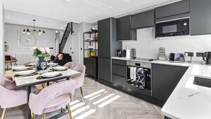 Eine moderne Küche mit schwarzen Schränken, einer Mikrowelle und einer Kaffeemaschine.