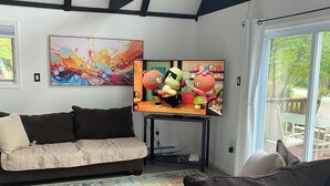 Una sala de estar moderna con un televisor grande, un sofá y una mesita de centro.