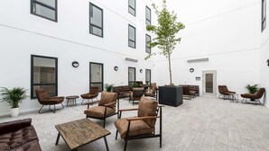 A spacious outdoor seating area with multiple sofas and chairs, a central coffee table, and a potted plant. - Modern Apartments in Hollis Croft Sheffield (Sheffield)