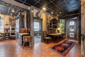 A rustic interior with a kitchen area, wooden furniture, and a dining table.