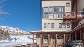 A hotel with a covered outdoor area, a mountain backdrop, and a two-story building with balconies. - Shirana #7 2 Bedroom Plus Loft (Mountain Village)