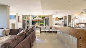 Ein modernes Wohnzimmer mit Sofa, Esstisch und Küchenzeile.