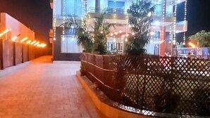 A multi-story building with a modern design, featuring a central courtyard with a decorative fence and potted plants.