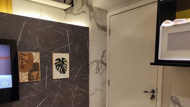 Une salle de bain avec un mur en marbre, un lavabo et une porte.