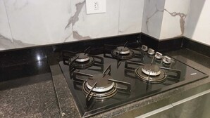 Une cuisine avec une plaque de cuisson noire et un dosseret en marbre.