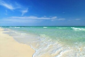 Una playa con agua turquesa cristalina y una orilla arenosa.