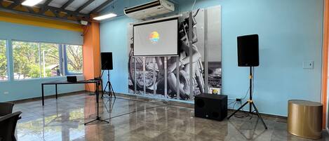 A spacious room with a stage, a projector, and a screen.
