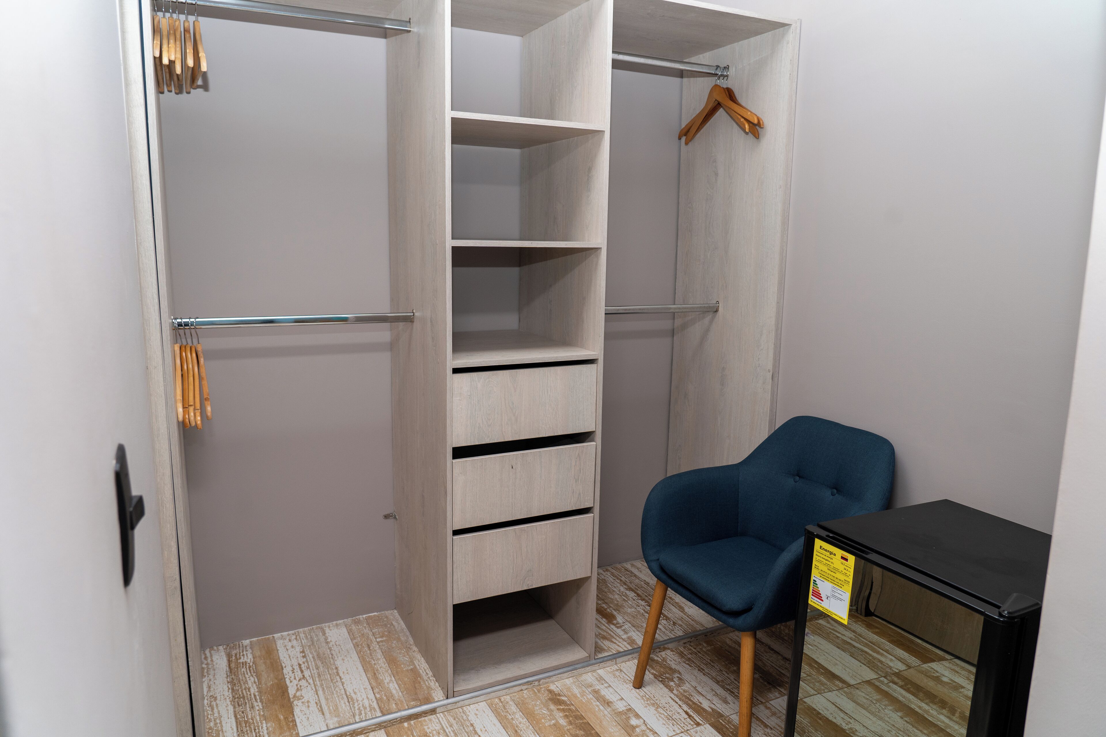 A walk-in closet with open shelves and a chair.
