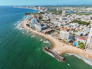 An aerial view of a coastal city with a beach, hotels, and a pier. - Sunset Palace Beach Hotel - All Inclusive (Mazatlán)