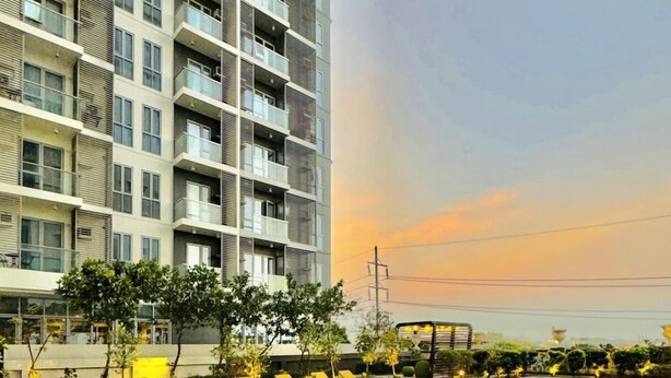 A swimming pool with lounge chairs and a modern building in the background. - Exclusive 1BR Residences at LaFayette Park Square (Iloilo City)