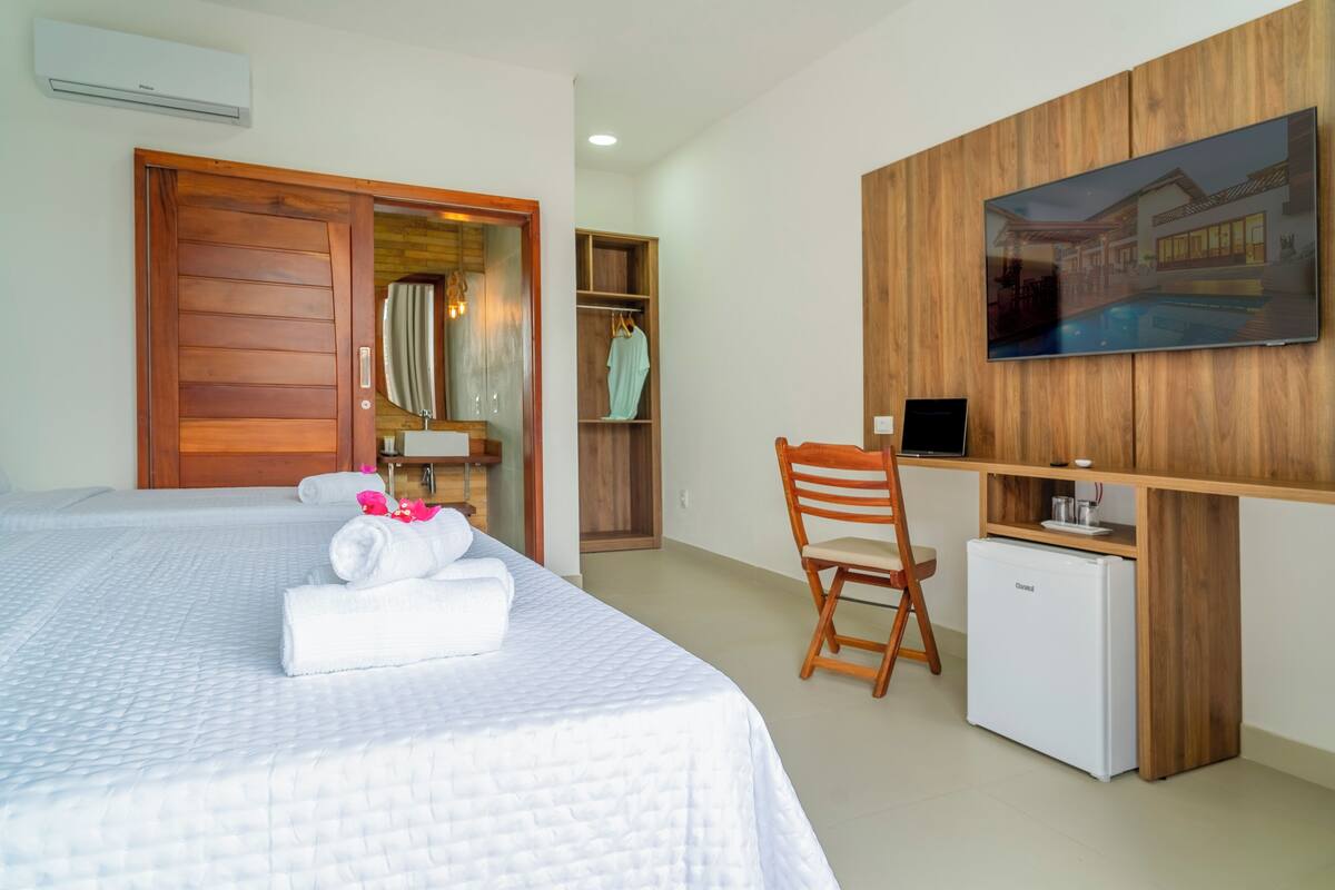 Une chambre d’hôtel équipée d’un lit, d’un bureau, d’une télévision et d’un mini-réfrigérateur.