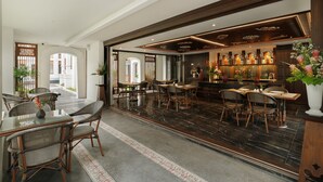 Un restaurante con barra, mesas y sillas para comer.