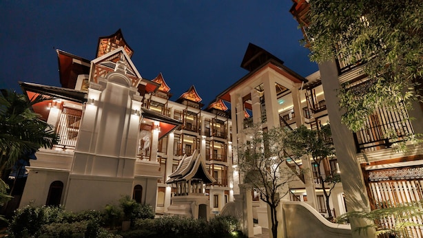 Un hotel de varios pisos con elementos arquitectónicos tradicionales, como tejados escalonados y balcones ornamentados.