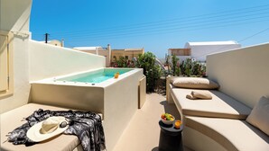 En tagterrasse med jacuzzi, udend ørs møbler og udsigt over byen.