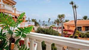 A resort with multiple buildings, palm trees, and a view of the ocean. - Tenerife Royal Gardens - Beachfront Bliss. Studio Apartment Sea/Pool views. (Playa de la Américas)