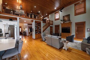 A spacious living area with a wooden ceiling, a staircase, and a kitchen with modern appliances. - 15 mi to KY Derby Churchill Downs! Lux Estate 6 BR 4b/2hb HEATED POOL, sleeps 14 (New Albany)