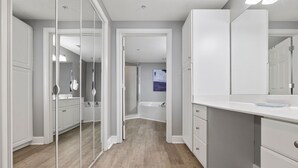 Ein modernes Badezimmer mit Duschkabine aus Glas, einem weißen Waschtisch und einem großen Spiegel.