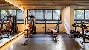 A gym with exercise equipment, large windows, and a wooden ceiling. - OCB - Luxo e Conforto Campo Belo (São Paulo)