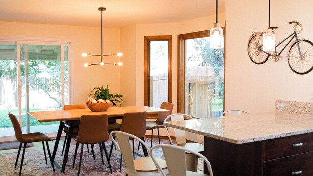 Una cocina moderna con comedor, piso de madera y una isla grande.