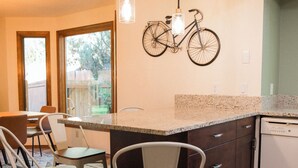 Una cocina moderna con una isla grande, taburetes de bar y una bicicleta colgada en la pared.