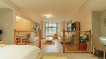 A spacious room with a bed, a desk, a chair, and a bookshelf.