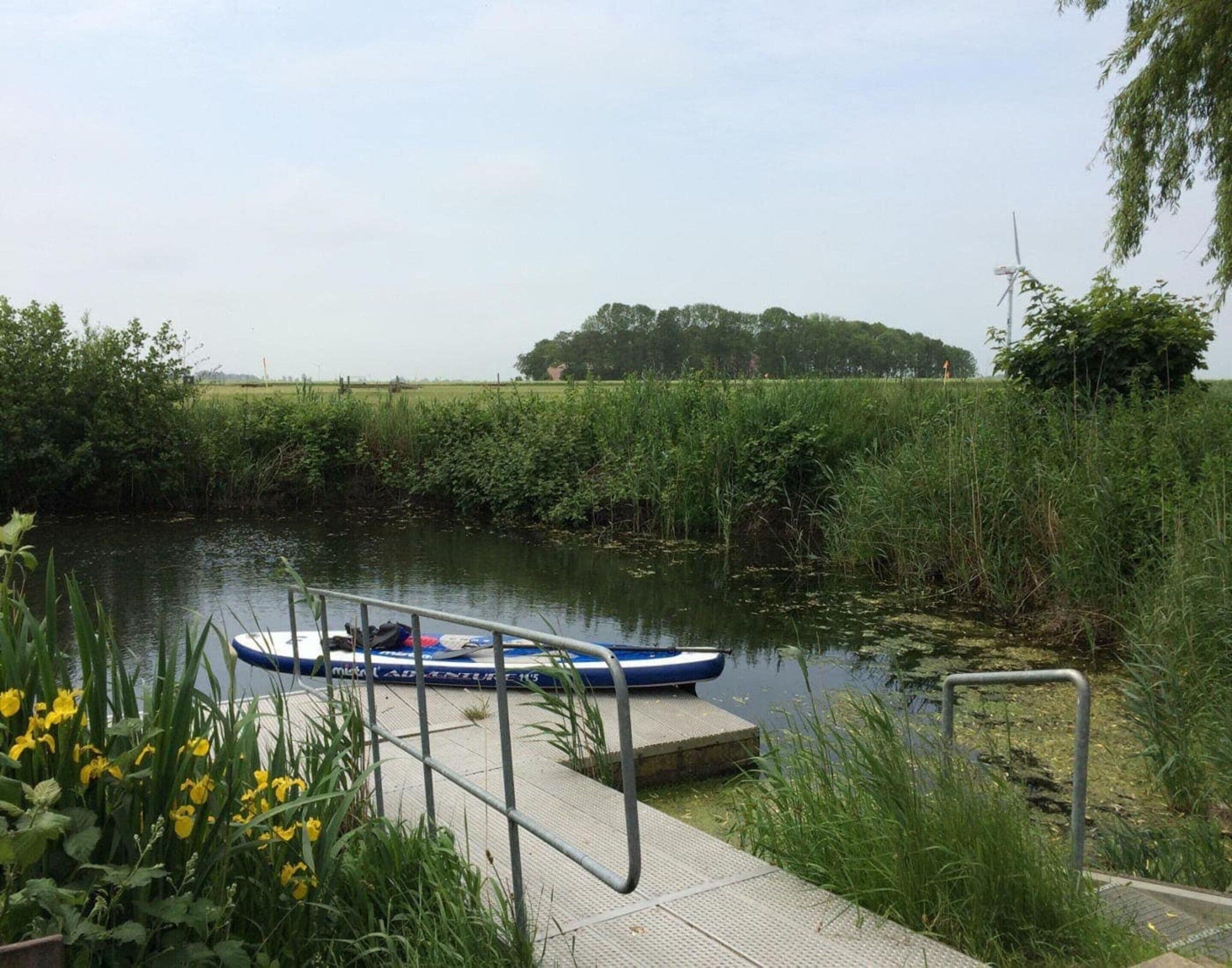 A calm river with a dock and a boat.