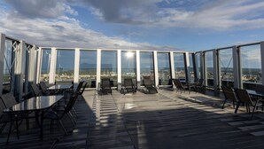 A rooftop terrace with glass walls, outdoor seating, and a city view. - Comfortable Apartment, Center of Szczecin (Szczecin)
