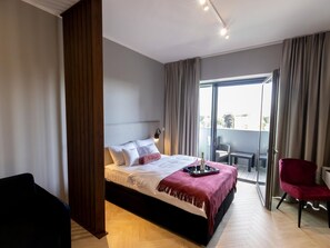 Relax in comfort with a spacious bed, a seating area, and a balcony offering views of the surrounding area.