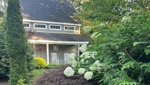 A cottage with a sign reading '14B Cove Cottage,' surrounded by lush greenery and a well-maintained garden. - Secluded Cottage with Beach Access! [Cove Cottage] (Tremont)
