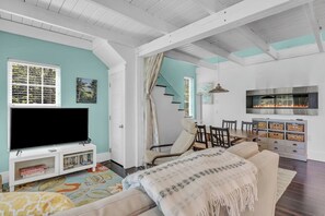 A living room with a TV, sofa, and fireplace. - Secluded Cottage with Beach Access! [Cove Cottage] (Tremont)