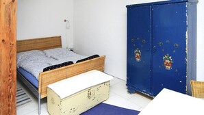 Een slaapkamer met een bed, een dressoir en een kledingkast.