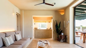 A modern living room with a sofa, a wooden coffee table, and a ceiling fan. - 3 Bedroom Villa, Private Pool, 500m to Binisafua Beach (Binisafau)