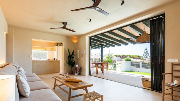 A spacious living area with a sofa, a wooden table, and a view of the outdoors through a glass door. - 3 Bedroom Villa, Private Pool, 500m to Binisafua Beach (Binisafau)