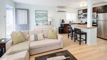 Un appartement moderne comprenant un salon, une cuisine et un coin repas.