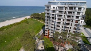 A multi-story hotel with balconies, located near a beach. - Apartment in Dziwnowek With Sea View (Dziwnów)