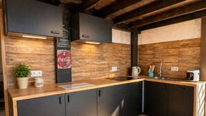 A modern kitchen with wooden cabinetry, a countertop, and a coffee station. - Apartment in Dziwnowek With Sea View (Dziwnów)