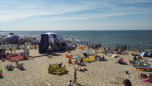 A crowded beach with various tents and beachgoers. - Apartment in Dziwnowek With Sea View (Dziwnów)