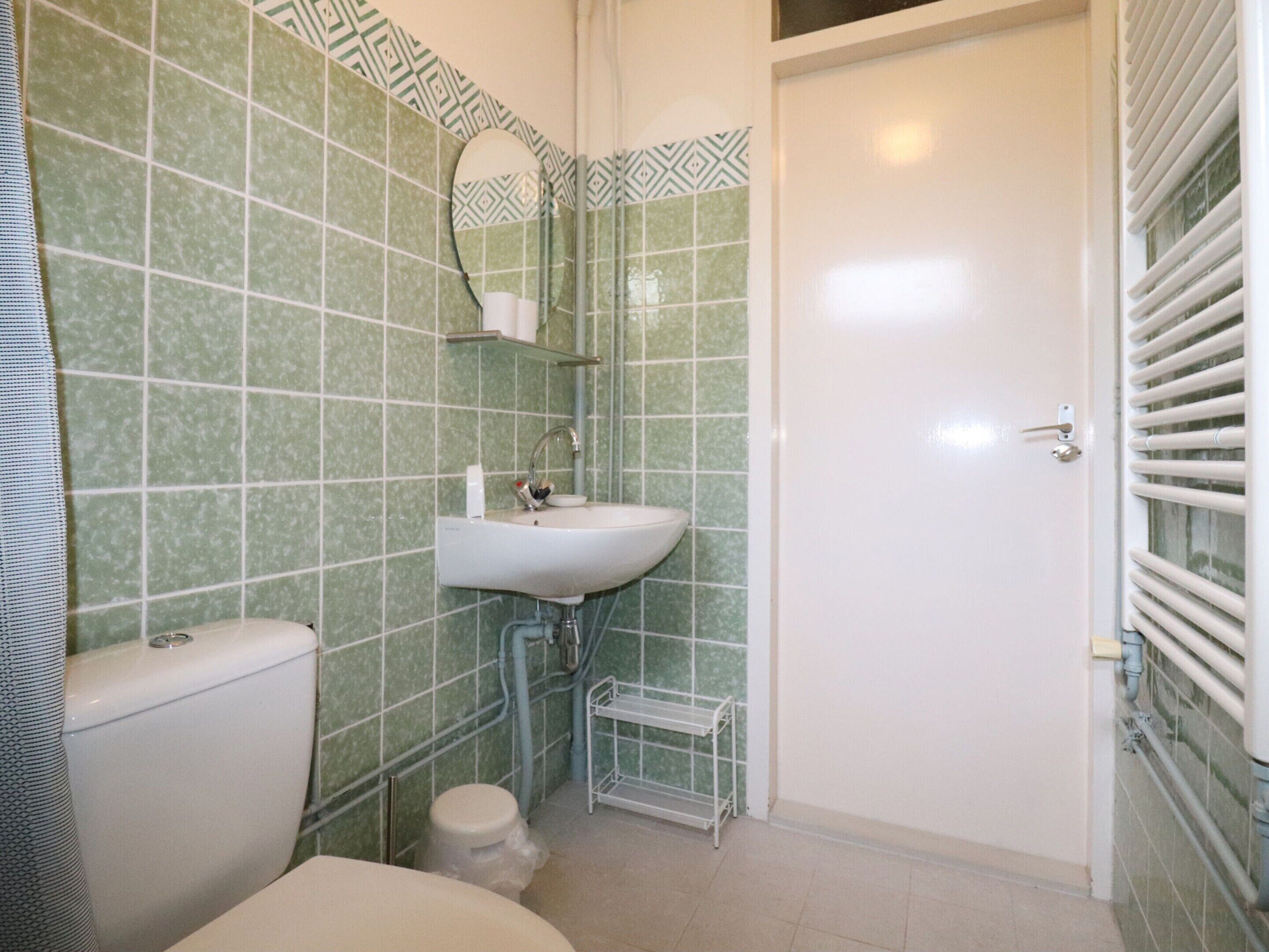 Une salle de bain comprenant des toilettes, un lavabo et un espace douche.