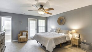 A bedroom with a bed, nightstand, chair, and ceiling fan. - Townhome 3 Mi to Wescott Park & Golf Course! (Ladson)