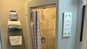 A bathroom with a shower, toilet, and sink.