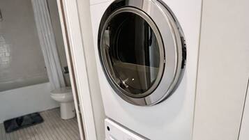 A compact, modern laundry room with two stacked front-loading washing machines.