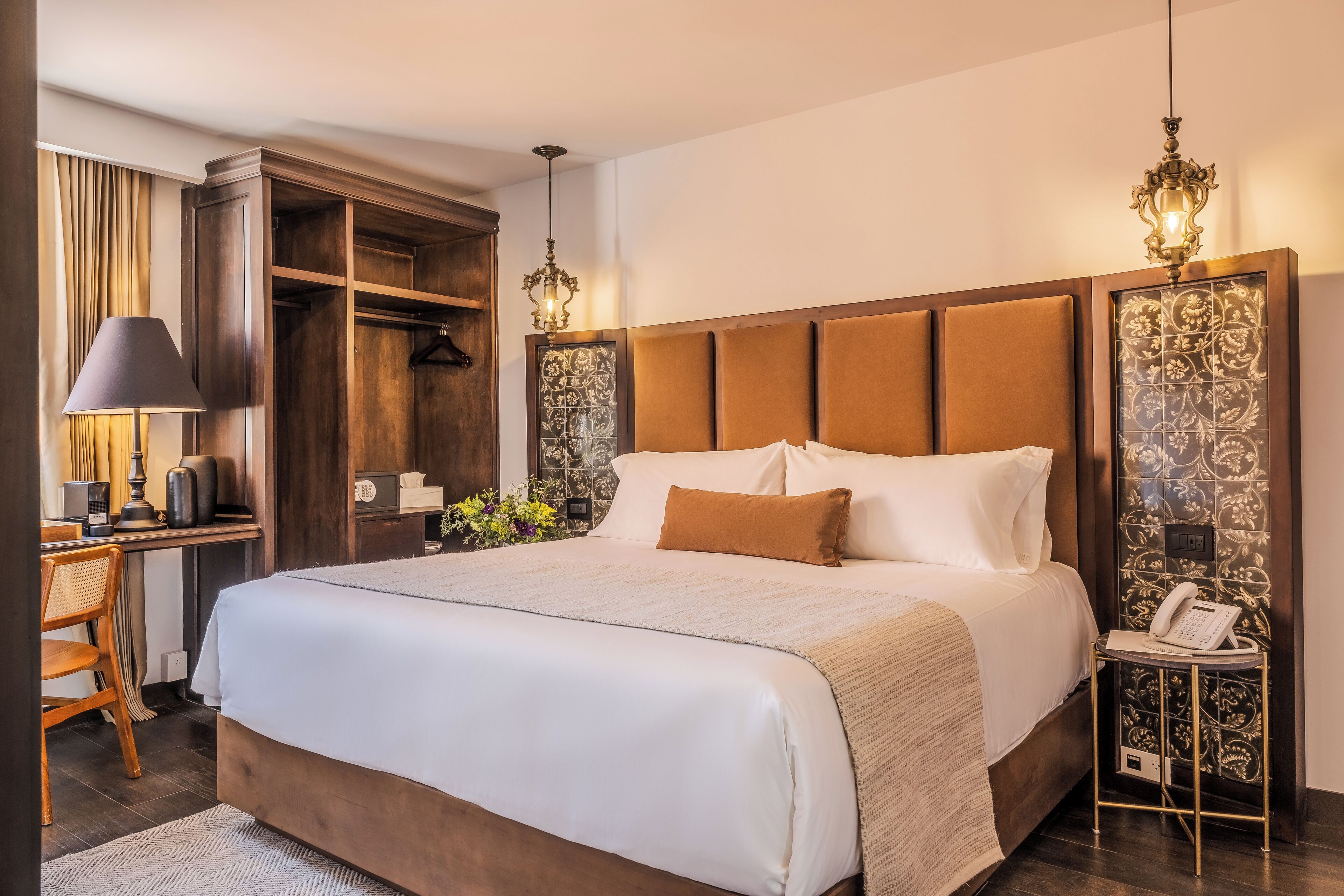 Ein geräumiges Schlafzimmer mit einem großen Bett, einem Schreibtisch mit Lampe und einem Kleiderschrank.